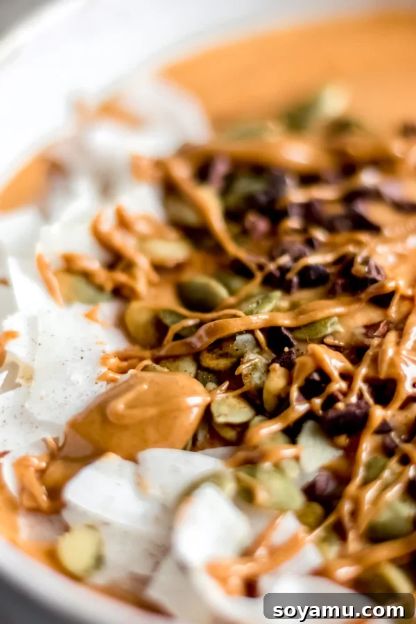 Fall Glow Smoothie Bowl - A delicious, creamy smoothie made with real food ingredients and lots of fall flavor. All you need for this filling breakfast is 6 ingredients and 10 minutes! #bluebowlrecipes #fall #smoothie #smoothiebowl #sweetpotato #dairyfree #vegan #glutenfree #breakfast #healthybreakfast | bluebowlrecipes.com Close-up of a vibrant fall glow smoothie bowl, showcasing its creamy texture and fresh toppings.