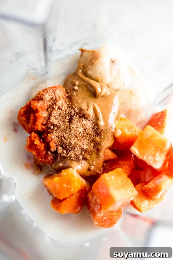 Fall Glow Smoothie Bowl - A delicious, creamy smoothie made with real food ingredients and lots of fall flavor. All you need for this filling breakfast is 6 ingredients and 10 minutes! #bluebowlrecipes #fall #smoothie #smoothiebowl #sweetpotato #dairyfree #vegan #glutenfree #breakfast #healthybreakfast | bluebowlrecipes.com Fall smoothie ingredients laid out next to a blender, ready for preparation.
