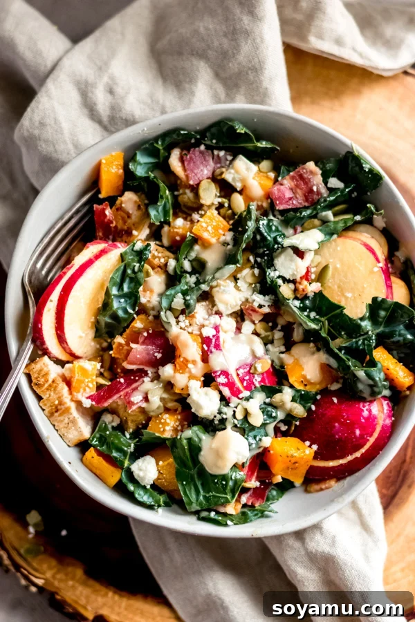 Fall Harvest Salad with Maple Tahini Dressing - A delicious salad filled with fall flavors and good-for-you ingredients like roasted butternut squash, honeycrisp apples, chicken, kale, and pumpkin seeds. No sad salads here! #butternutsquash #salad #fall #fallrecipes #mealprep #healthyrecipes #healthyfood #chicken #glutenfree | bluebowlrecipes.com Another enticing view of the Fall Harvest Salad, highlighting the fresh, colourful ingredients mixed with the creamy dressing.