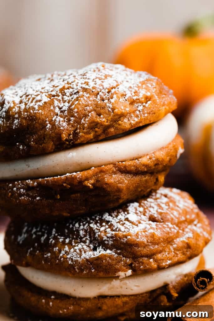 Brown Butter Pumpkin Whoopie Delights 10 A close-up of two pumpkin whoopie pies, perfectly sandwiched with rich cream cheese filling, showing the delicate texture of the cakes.
