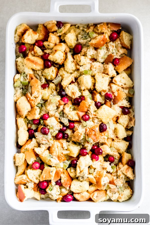 Brioche Stuffing Ready to Bake Finished brioche stuffing mixture with fresh cranberries in a pot, seasoned and ready to be transferred to a baking dish.