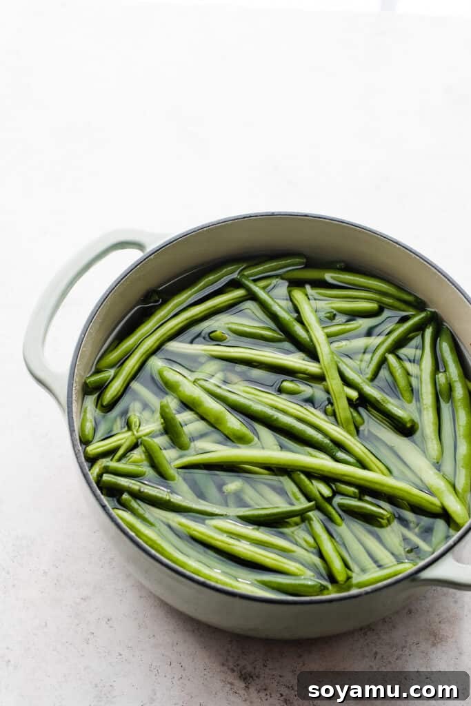 Effortless Gluten-Free Dairy-Free Bacon Green Beans 4 A dutch oven filled with fresh, uncooked green beans and water.