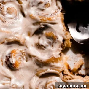 Cinnamon rolls in a pan frosted with cream cheese icing.