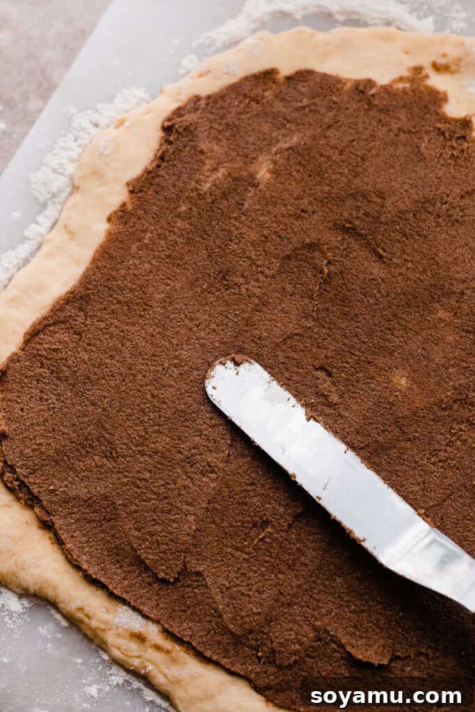 Rich cinnamon filling evenly spread over the brioche dough rectangle.