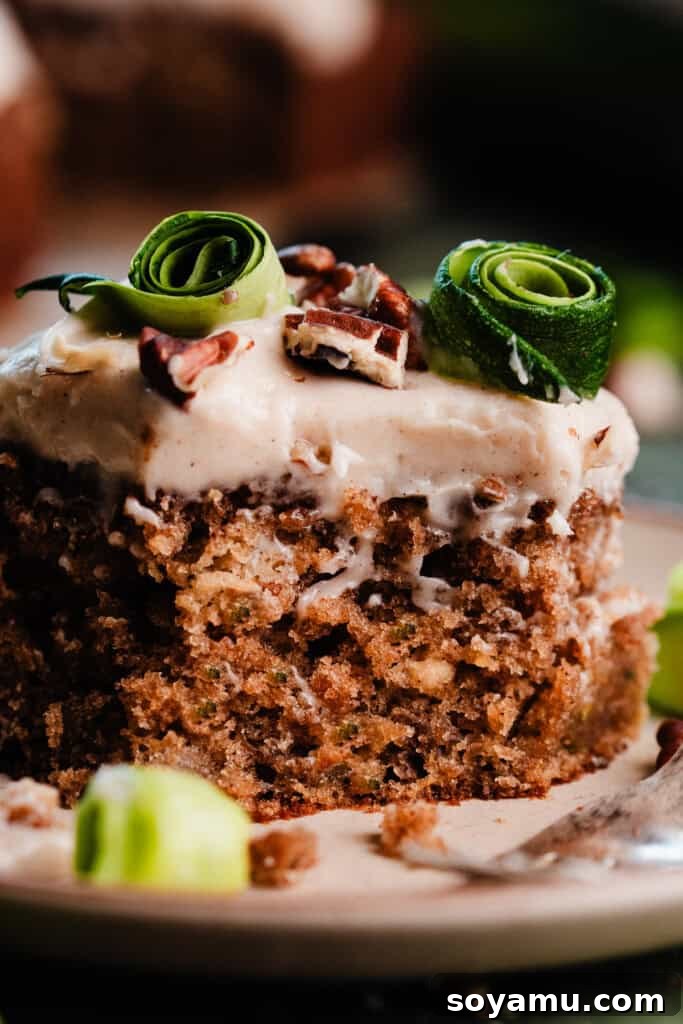 Irresistible Zucchini Snack Cake with Brown Butter Cream Cheese Frosting 3 A close-up shot of a slice of the zucchini cake, generously frosted and showing its moist interior, with a few bites gently taken.
