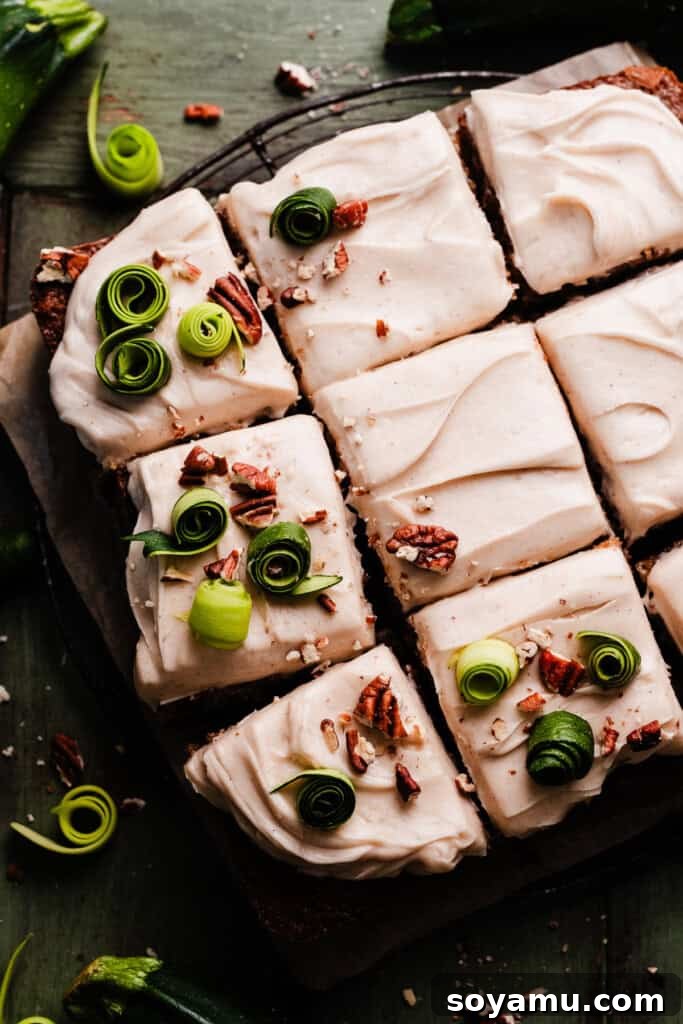Irresistible Zucchini Snack Cake with Brown Butter Cream Cheese Frosting 8 The fully frosted 9-inch square zucchini cake, elegantly decorated with chopped nuts and delicate zucchini spirals, showcasing its delicious appeal.