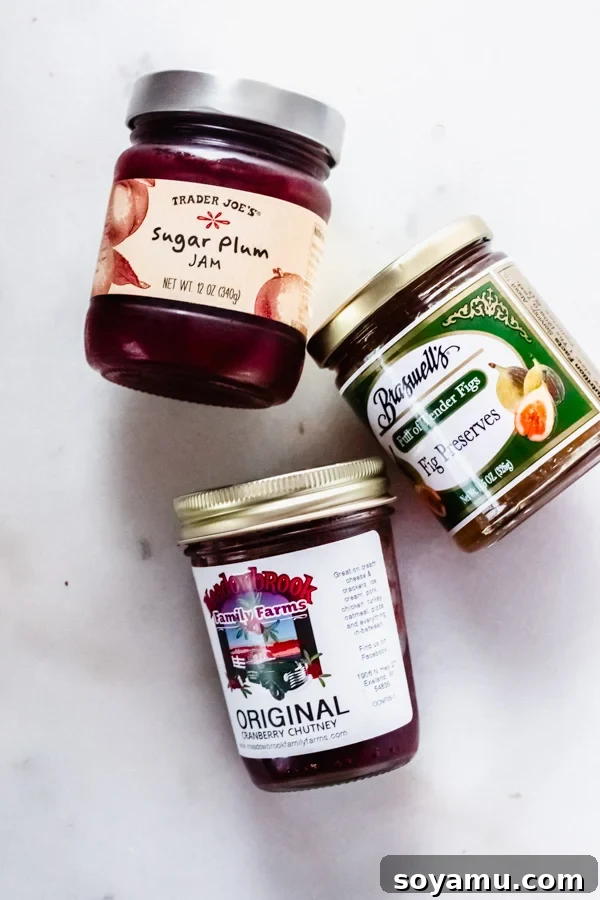 Selection of gourmet fruit spreads and jams for a cheese platter Jars of gourmet jams and fruit spreads, ideal for a cheese board.