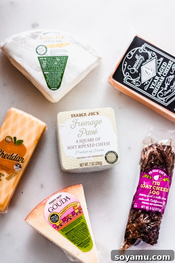 Variety of cheeses for a charcuterie board, including soft and hard options An assortment of different cheese types laid out on a white surface, ready for a board.