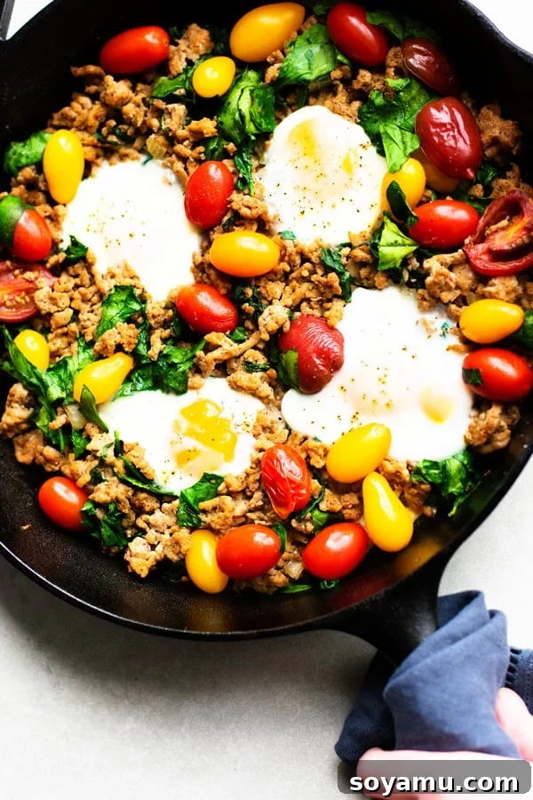 Healthy Taco Skillet - Versatile and veggie-packed for breakfast or dinner. A close-up of a Healthy Taco Skillet, loaded with ground turkey, vegetables, spices, and topped with soft eggs.
