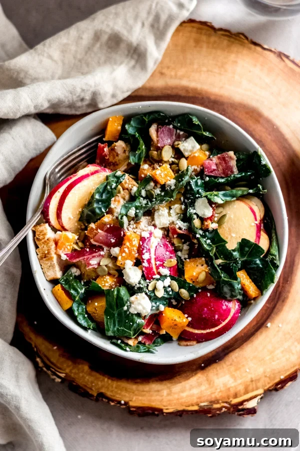 Fall Harvest Salad with Maple Tahini Dressing - Seasonal salad for fall and winter. A hearty Fall Harvest Salad with Maple Tahini Dressing, featuring kale, roasted squash, apples, and bacon.