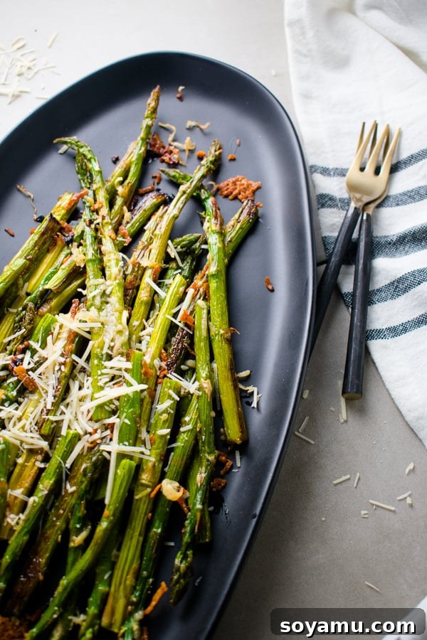 Parmesan Roasted Asparagus - Easy and addictive side dish. Crispy Parmesan Roasted Asparagus, garnished with additional parmesan cheese, baked to golden perfection.