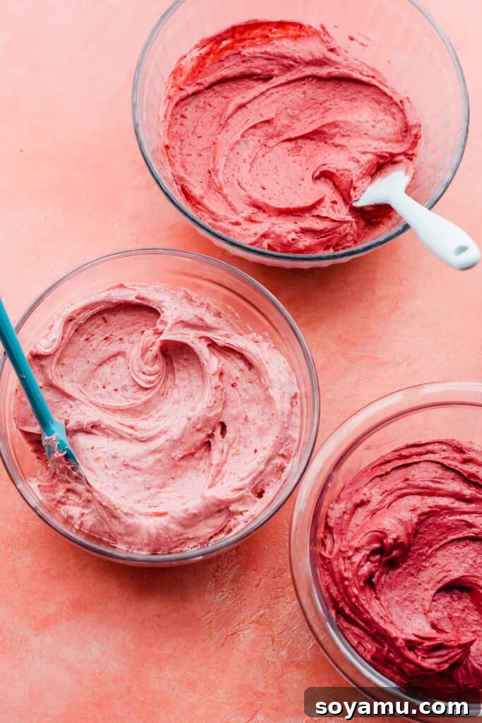 Bowls of raspberry frosting in various shades of pink. 