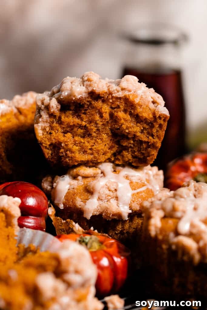 Maple-Drizzled Pumpkin Crumble Muffins 2 A close-up of half a muffin stacked on another, showing the fluffy insides.