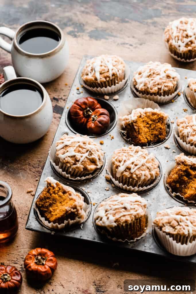 Maple-Drizzled Pumpkin Crumble Muffins 11 A vintage pan of the muffins on a wood surface.