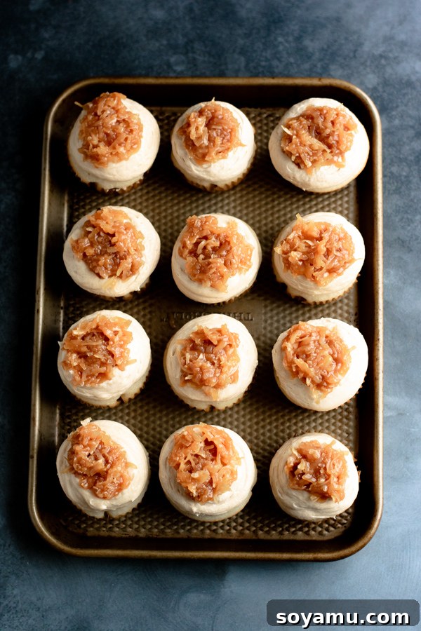 Luscious caramel coconut topping spread over salted caramel buttercream on a Samoa cupcake.