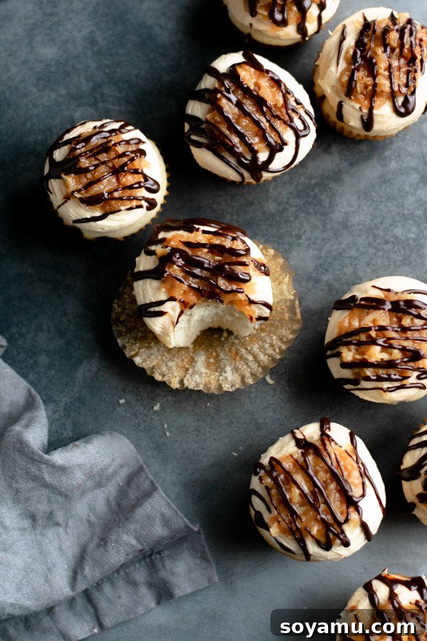 A tray of beautifully decorated Samoa cupcakes, showcasing all layers of topping.