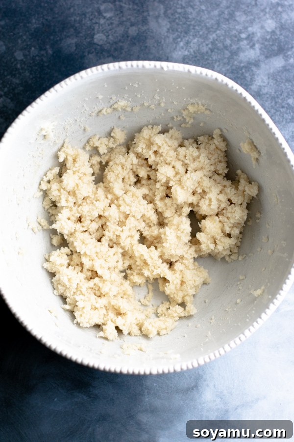 Cupcake batter being mixed in a large bowl, showing a smooth, creamy texture.