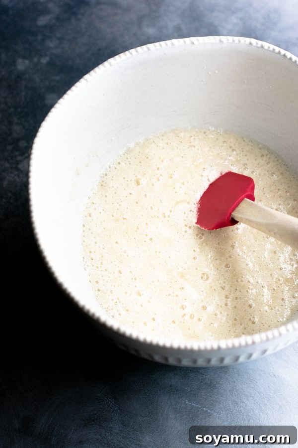 Cupcake batter continuing to mix in a bowl, showcasing its semi-thick consistency.