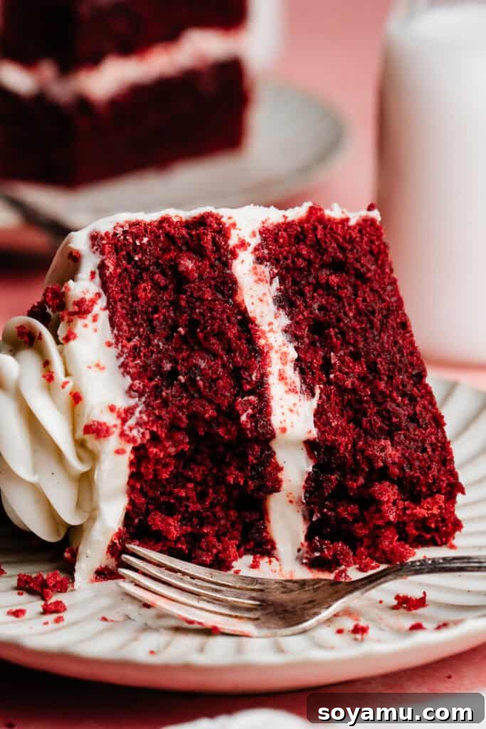 Decadent Red Velvet Dream 13 A close-up on a slice of the red velvet cake, with a few bites missing to show the fluffy, moist texture of the cake layers.