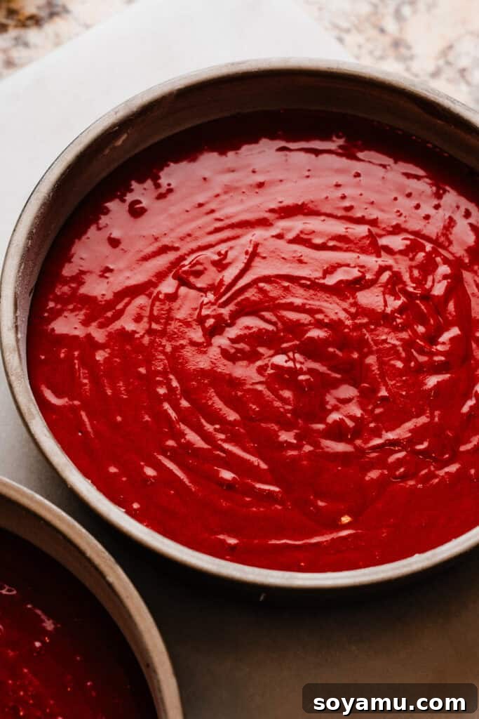 Decadent Red Velvet Dream 8 Cake pans full of vibrant red velvet cake batter, perfectly portioned and ready to be baked.