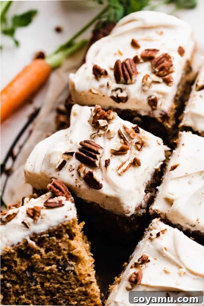 Silky Cream Cheese Frosting Perfection 8 A close-up of beautifully cut squares of moist carrot cake, generously topped with swirls of homemade cream cheese frosting and a sprinkle of chopped walnuts.
