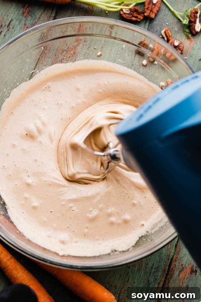 Brown Butter Cream Cheese Frosted Carrot Cupcakes 5 A stand mixer vigorously beating eggs and sugar until the mixture transforms into a pale and thick, airy consistency.