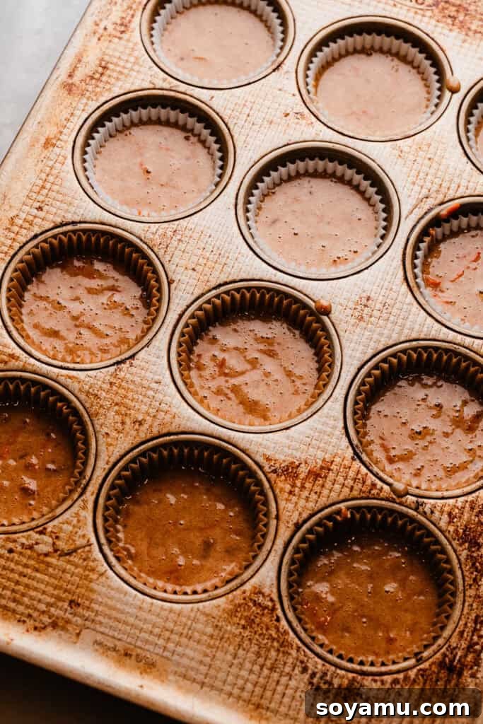Brown Butter Cream Cheese Frosted Carrot Cupcakes 7 A cupcake pan filled with carrot cake batter, meticulously poured into each liner, ready to be placed into the oven for baking.
