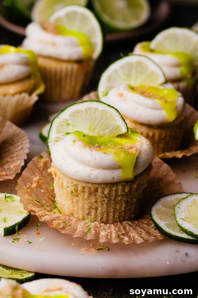 A close-up on a key lime cupcake with the wrapper peeled back.