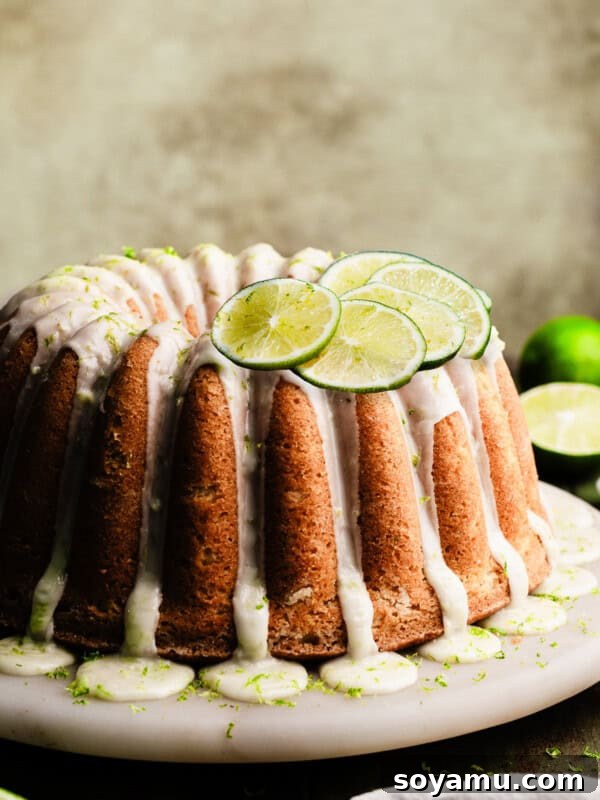 The glazed key lime bundt cake on a marble cake plate.