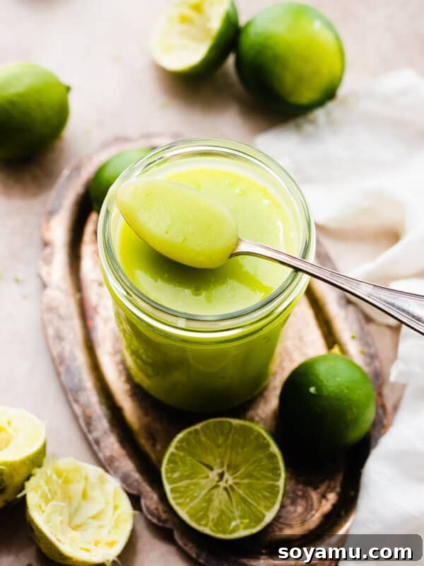 Ultra-Creamy Key Lime Pie Recipe for Perfectly Tangy Slices 18 A spoon resting on a jar of bright green lime curd.