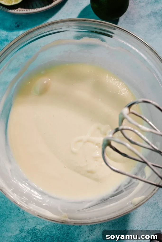 Ultra-Creamy Key Lime Pie Recipe for Perfectly Tangy Slices 7 A bowl of cream cheese and sweetened condensed milk mixed together.