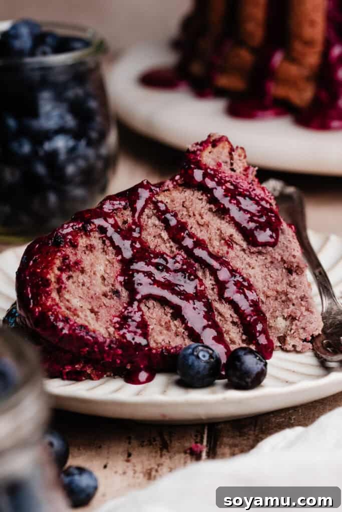 Double Blueberry Bundt Cake Recipe for Moist, Fruity Treat 16 A slice of blueberry bundt cake on a plate, drizzled with extra blueberry glaze.