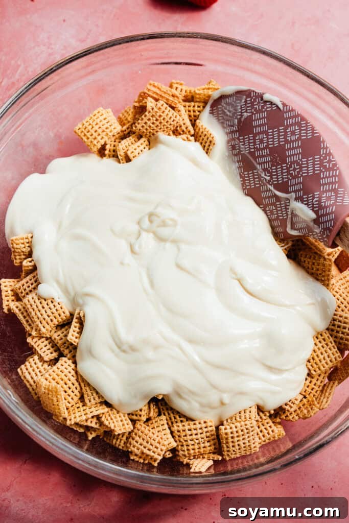 4-Ingredient Strawberries and Cream Puppy Chow Recipe 5 A bowl of chex with melted white chocolate poured in.