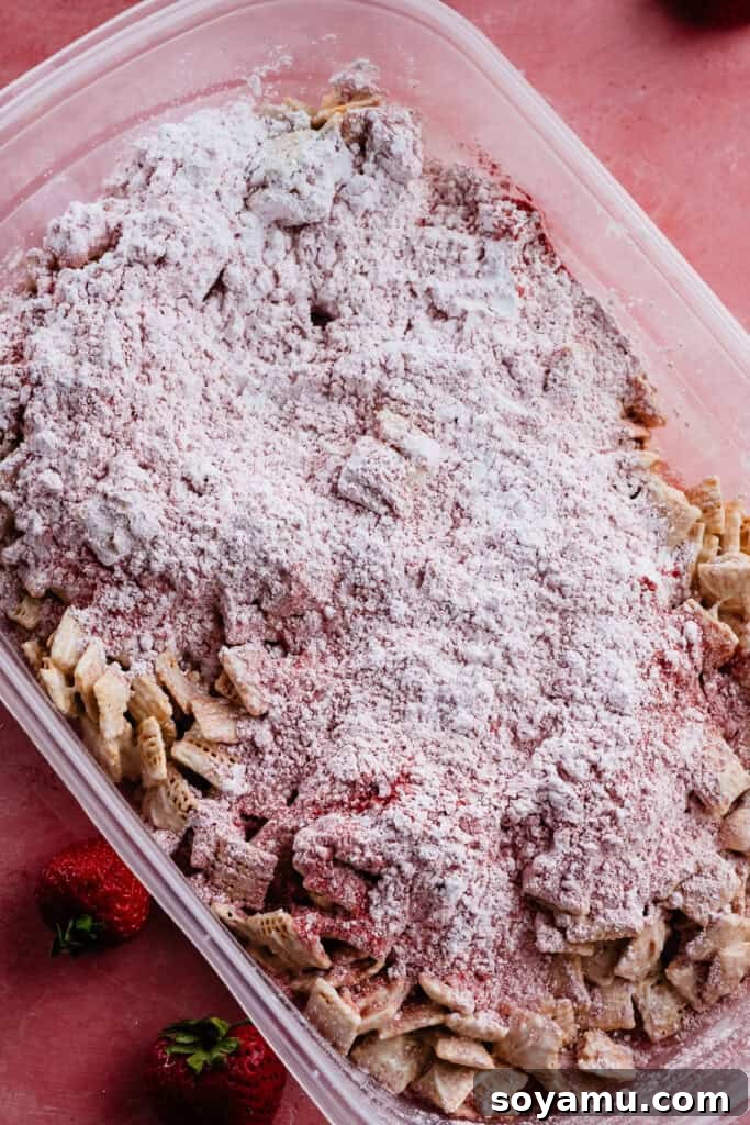 4-Ingredient Strawberries and Cream Puppy Chow Recipe 8 White chocolate-coated chex in a tupperware with the strawberry powdered sugar dumped on top.