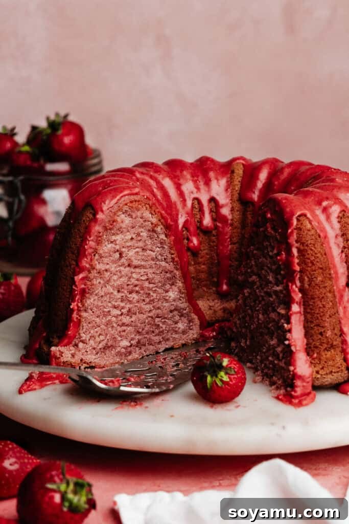 The sliced strawberry bundt cake on a cake plate, showing the fluffy texture inside.
