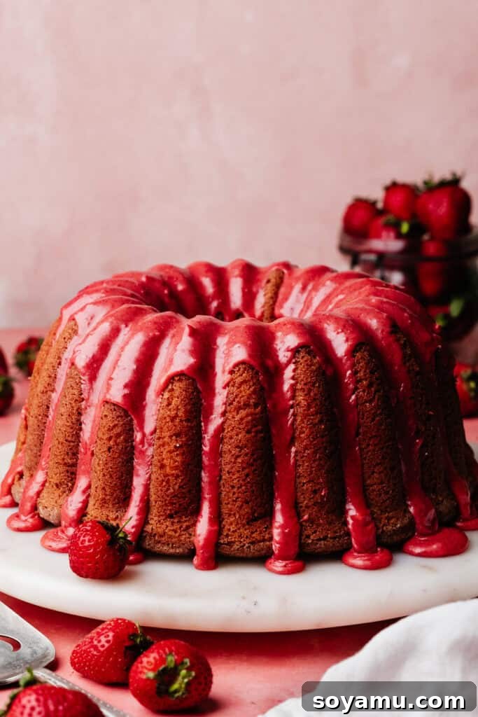 The strawberry bundt cake, glazed with vibrant pink strawberry glaze.