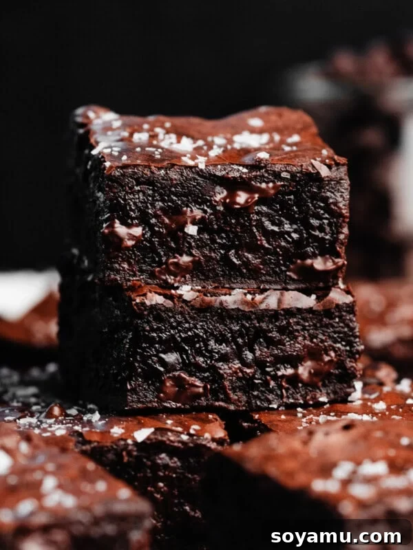 Sheet-Pan Brownies with Rich Chocolate Fudge Frosting 16 A close-up on a stack of two fudgy brownies topped with flaky sea salt.