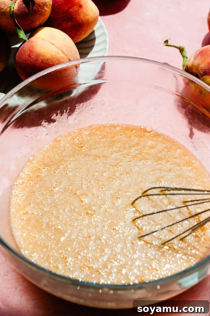 Southern-Style Peach Cobbler Muffins Recipe 7 A bowl of the wet ingredients whisked together.