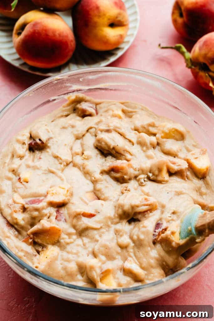 Southern-Style Peach Cobbler Muffins Recipe 10 A bowl of the slightly thick batter, with peach pieces stirred in.
