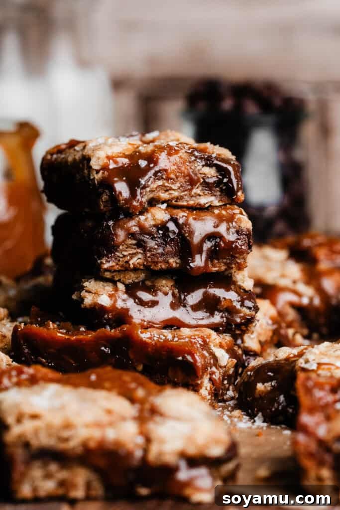 Carmelita Bars with Homemade Salted Caramel Filling 14 A stack of carmelita bars, dripping with melty salted caramel sauce and chocolate.