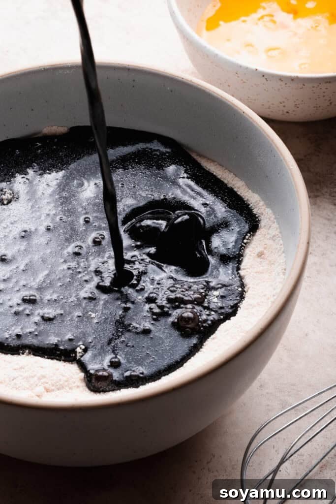 Decadent Moist Oreo Cake Recipe 7 The chocolate mixture being poured into the bowl of dry ingredients.